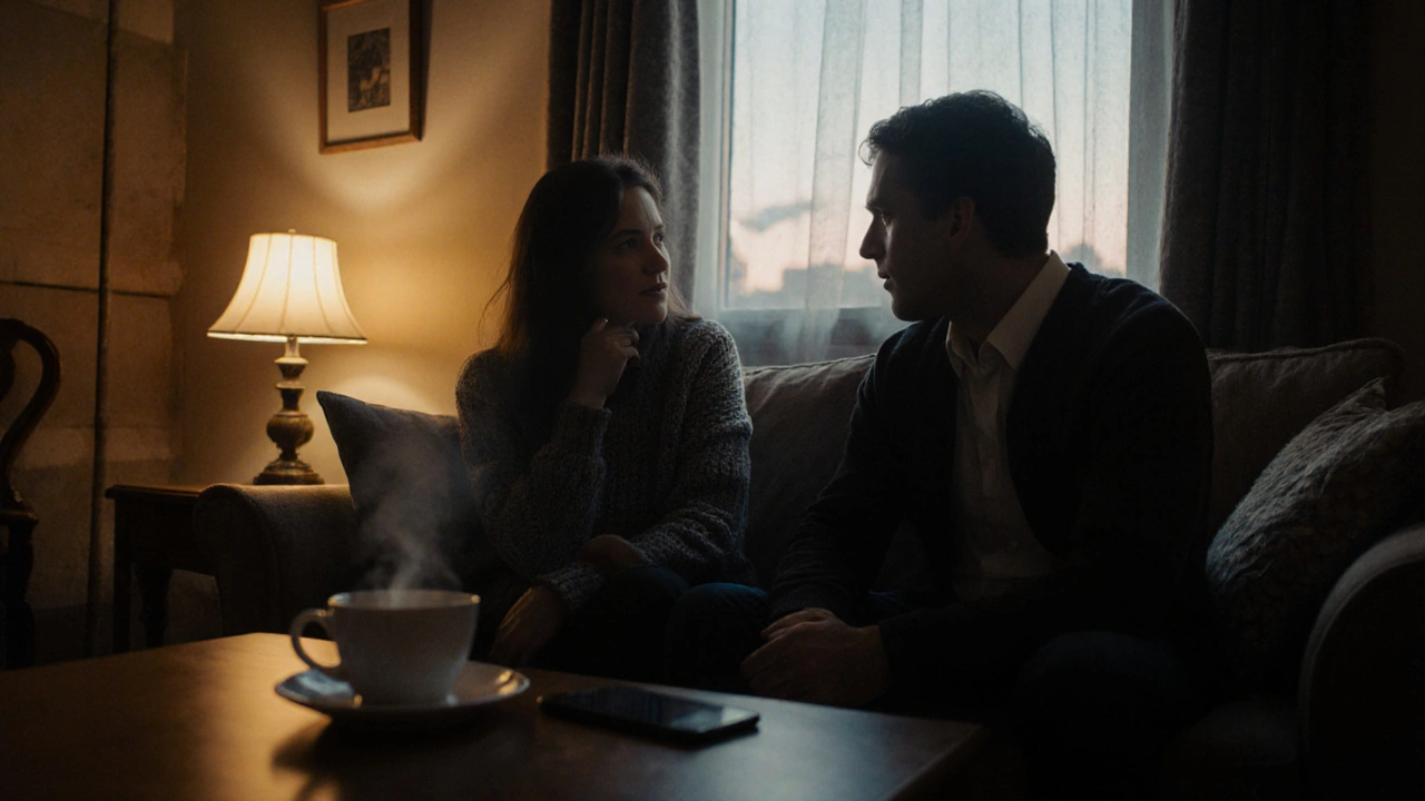 Dva lidé sedí spolu na sofě, hovoří a poslouchají bez telefonů, večerní osvětlení.